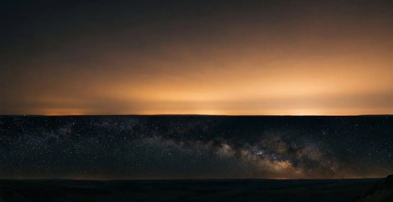Low-angle light dome from distant city visible on horizon despite remote dark sky location