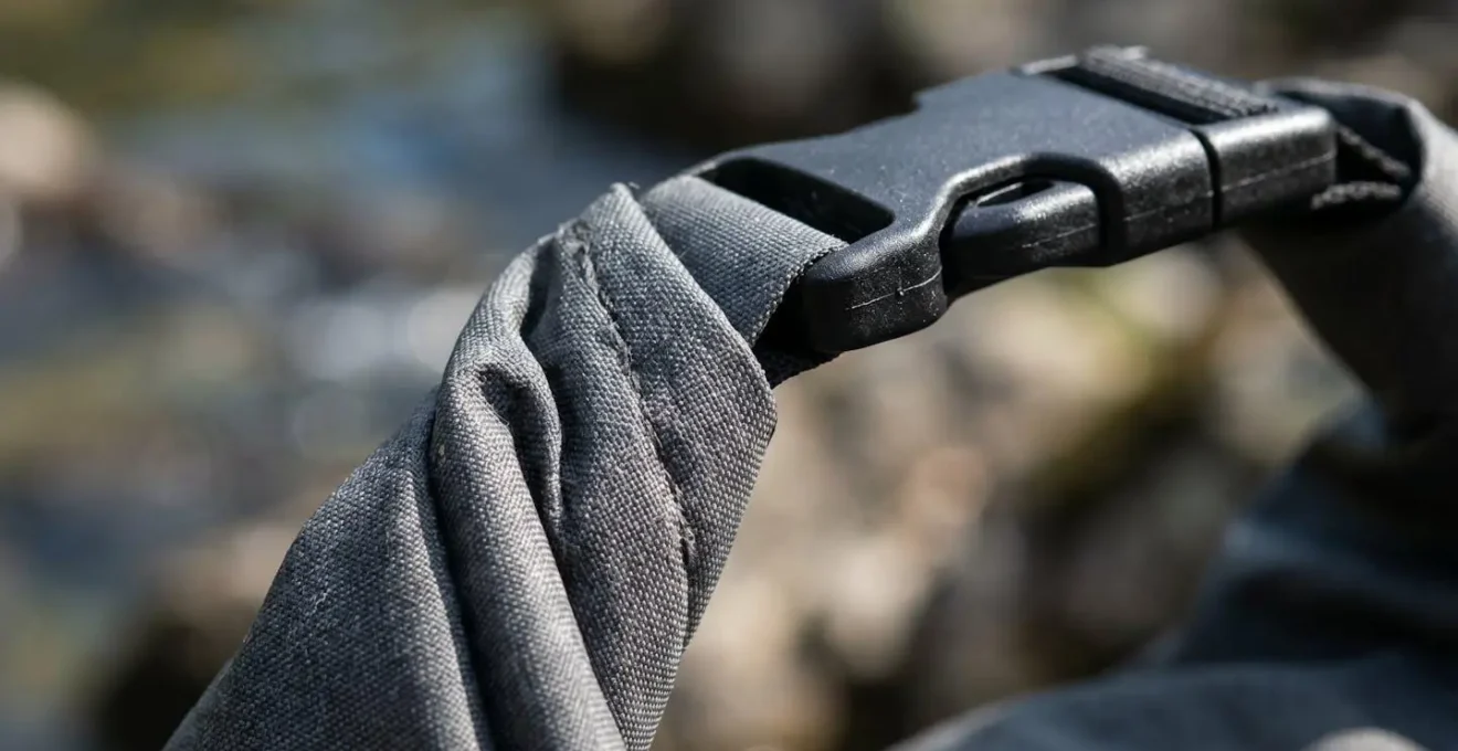Extreme close-up macro view of a roll-top dry bag closure showing the folded seal and clip mechanism in sharp detail
