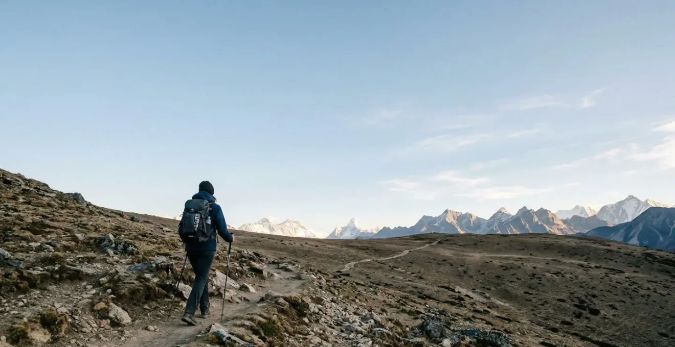 Trekker ascending a high-altitude plateau above 3000 meters under vast open sky