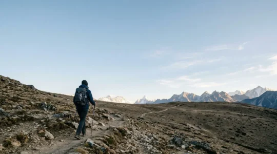 Trekker ascending a high-altitude plateau above 3000 meters under vast open sky