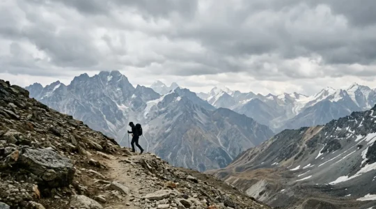 Mountaineer ascending steep alpine terrain at controlled pace with trekking poles under dramatic sky