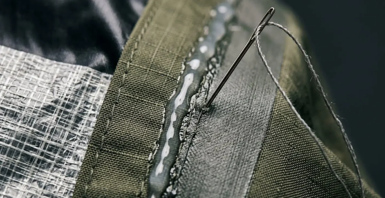 Extreme close-up of outdoor gear repair materials showing fabric texture and adhesive application detail